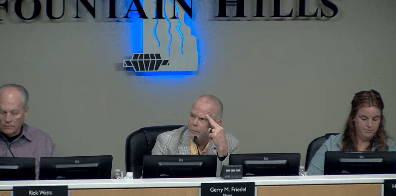 three people at a town council meeting