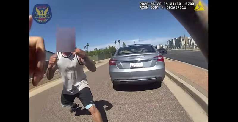 body-camera footage showing a man with a sleeveless shirt and tattoos down his arms squaring up to fight