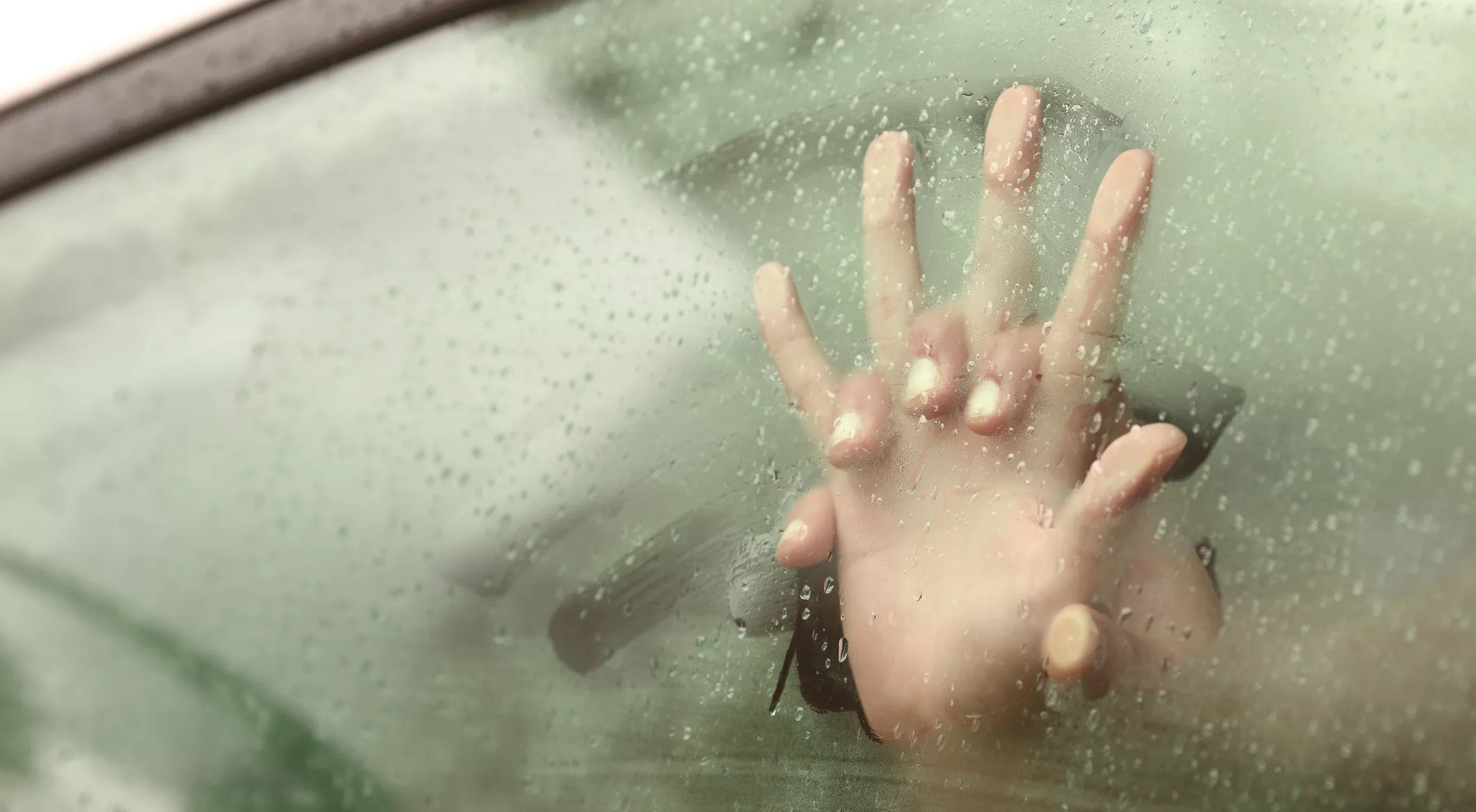 two intertwined hands against a steamy car window