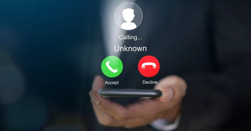 a hand holding a phone that is getting a call from an unknown number