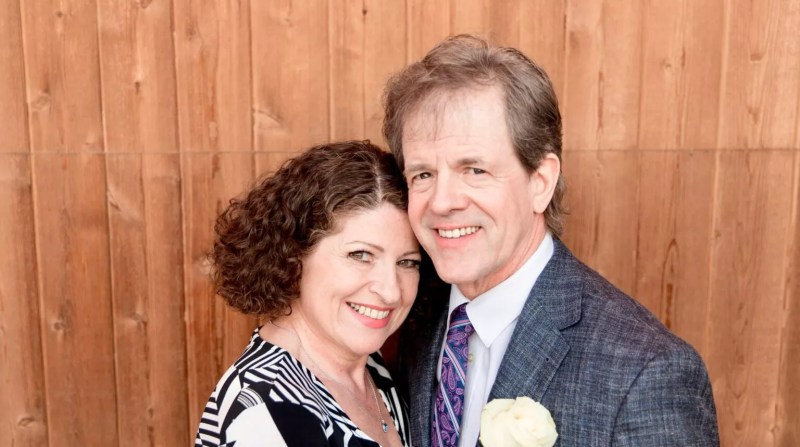 a man and woman pose at a wedding