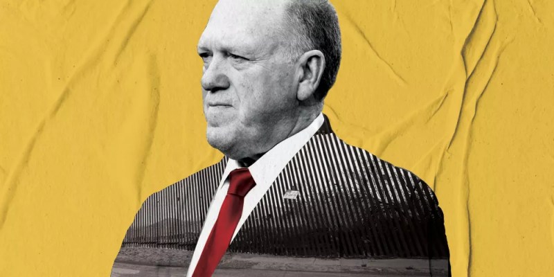 tom homan in a suit from the chest up, but the inside of the suit is a picture of a border wall