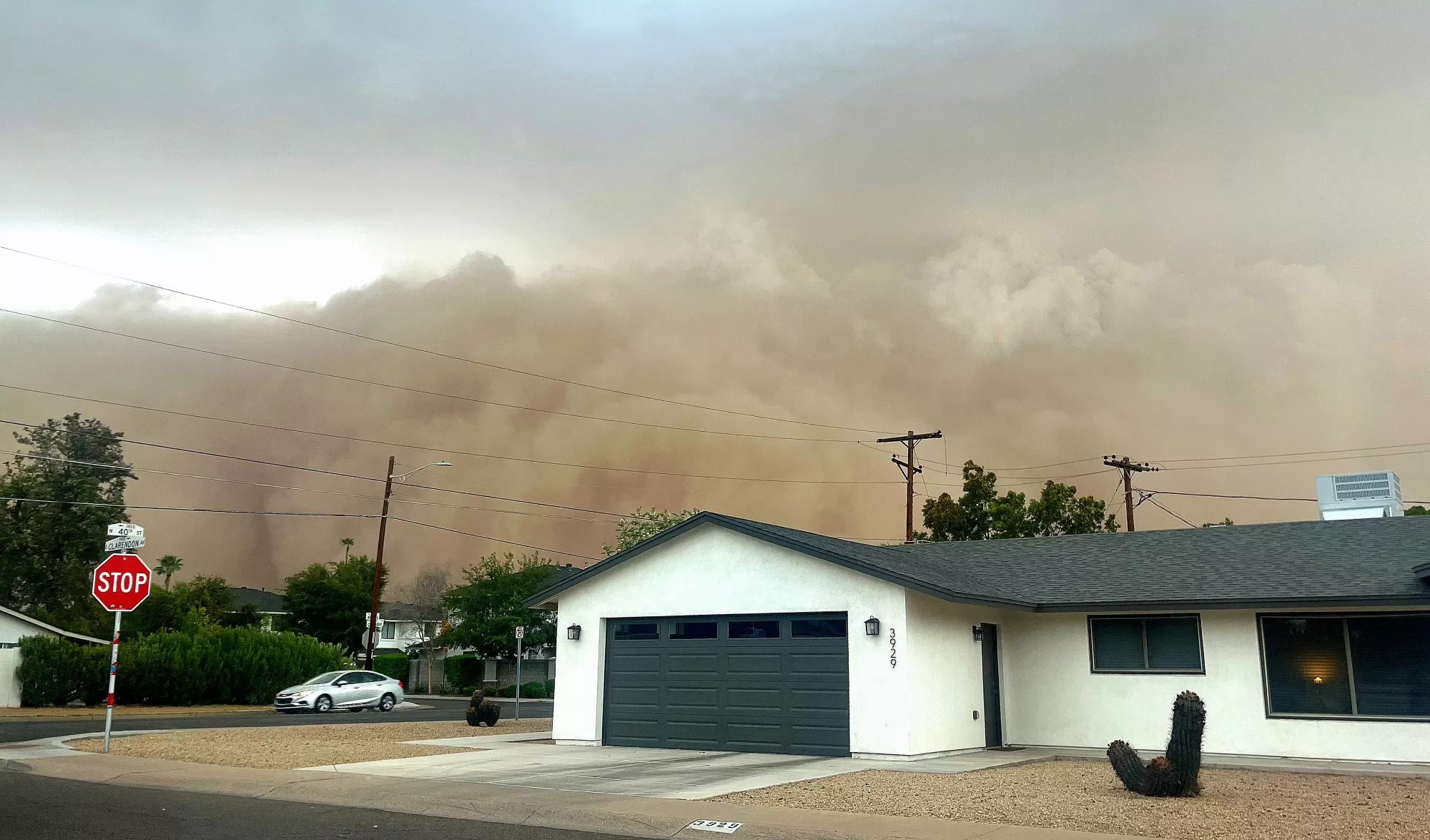 a haboob billows behind a white house