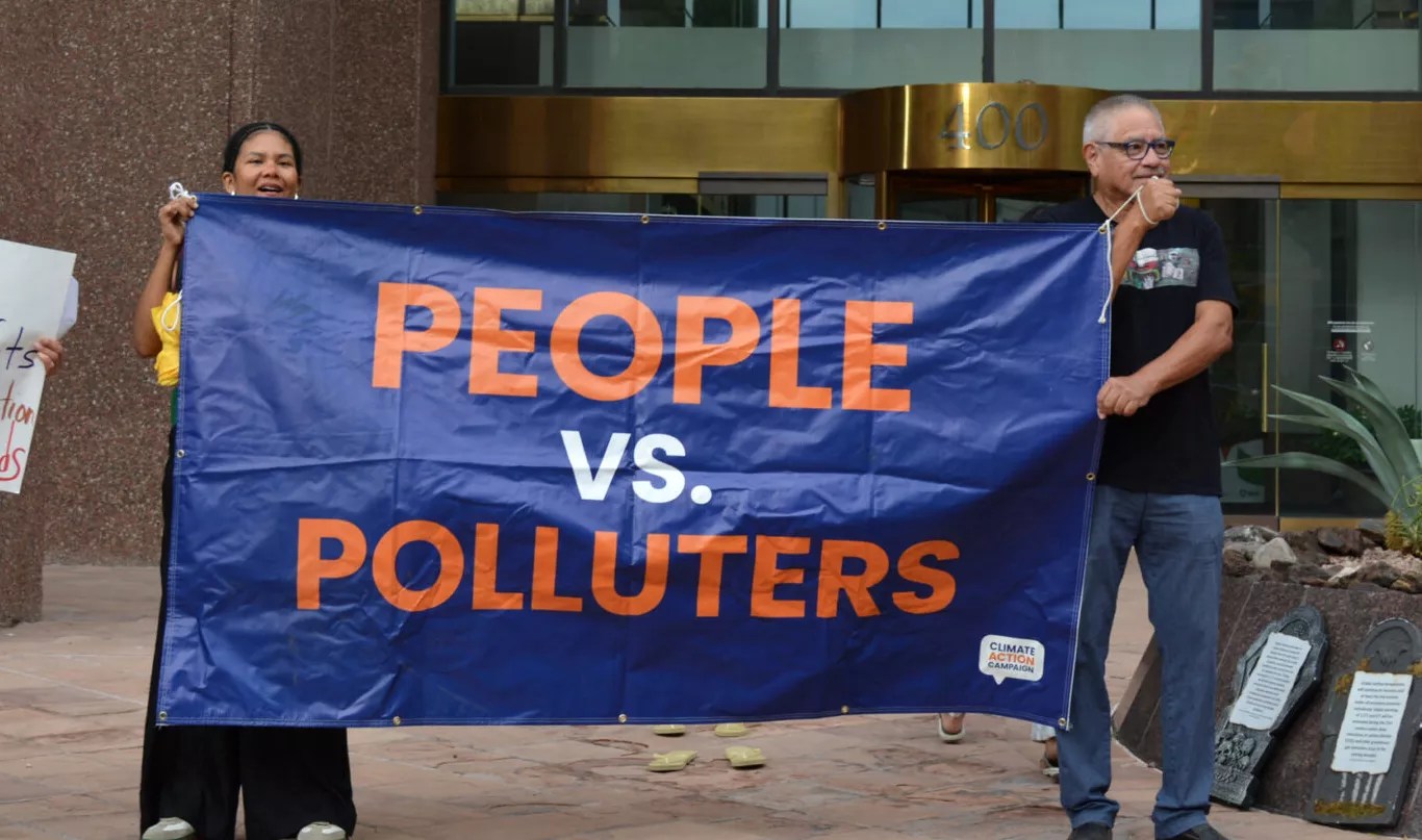 Protesters stand outside of Arizona Power Service’s headquarters on Thursday after the utility’s recent decision to walk back its clean energy goals.