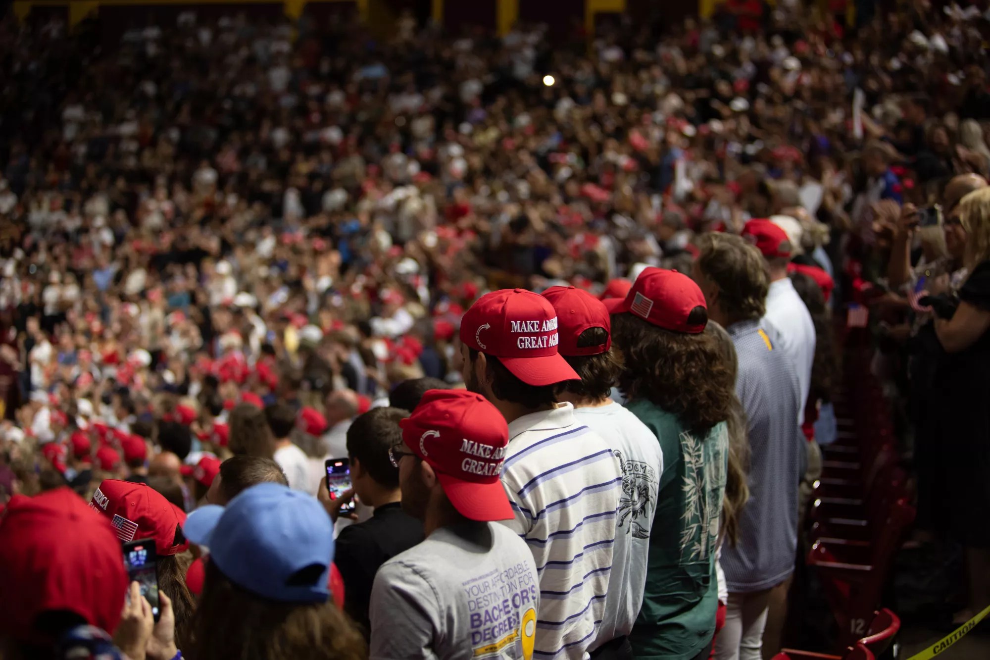a crowd of people in red MAGA hats