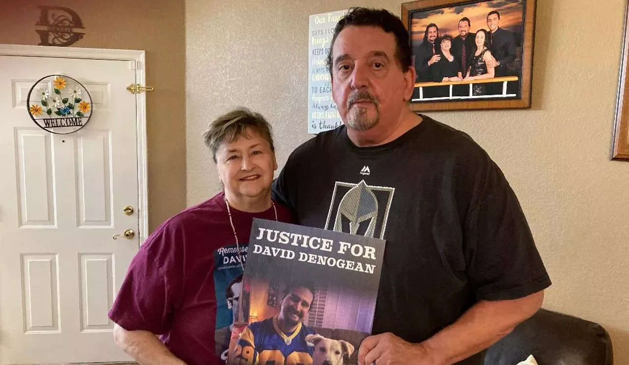 two people hold a poster that says "justice for david denogean"